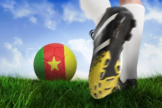 Close up of football boot kicking cameroon ball