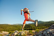 © Maygutyak - Hiker jumps over the rock