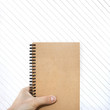 craft vertical blank notebook in man hand and wooden background
