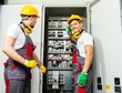 © Nejron Photo - Two electricians in a safety hat and headphones on a factory