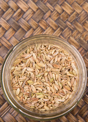 Wall Mural - Cumin seeds over a wicker background 