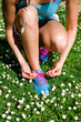Woman lacing running shoes in spring