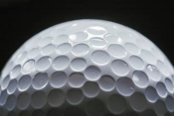 Wall Mural - A close-up of a golf ball over dark background