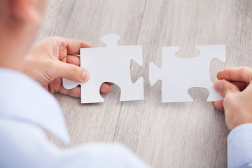 Poster - Cropped Image Of Businessman Joining Jigsaw Pieces