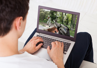 Poster - Man Playing Action Game On Laptop At Home