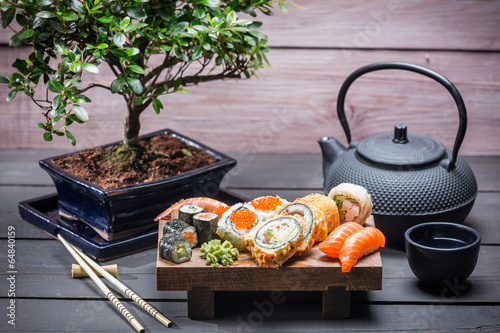 Obraz w ramie Sushi served on a wooden board with tea