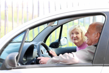 happy senior couple driving modern car on their vacation trip