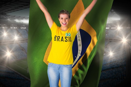 Excited football fan in brasil tshirt holding brasil flag
