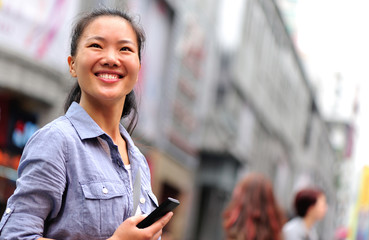 Wall Mural - leisure beautiful young asian woman use smart phone at street