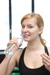 young woman drinking mineral water in a fitnessstudio