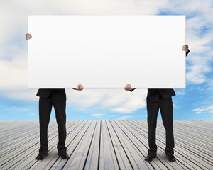 Men standing on wooden floor and lifting board