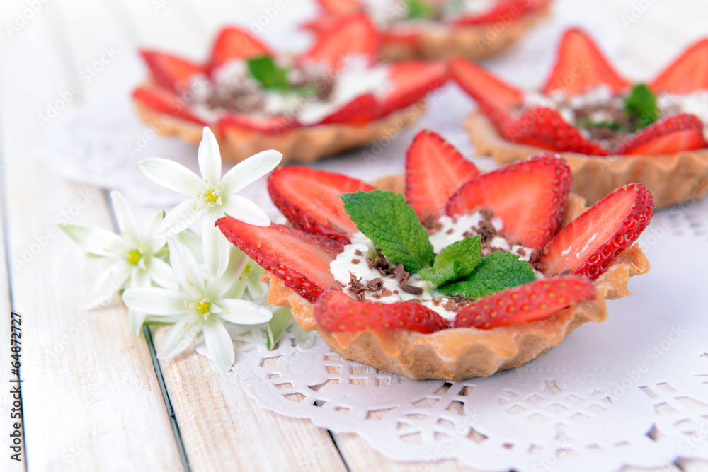 Tasty tartlets with strawberries on table close-up