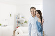 Cheerful couple inviting people to enter in home
