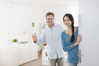 © jackfrog - Cheerful couple inviting people to enter in home