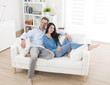 © jackfrog - cheerful couple relaxing in sofa at home