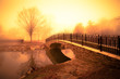 © littleny - morning light and fog over pond with footbridge