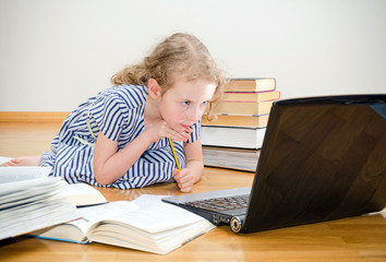 Smart little girl writes diploma at home.