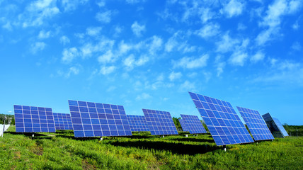 lots of solar panels, with beautiful clouds