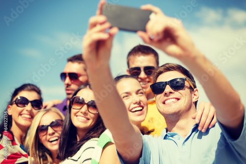 Fotografie, Tablou group of friends taking picture with smartphone