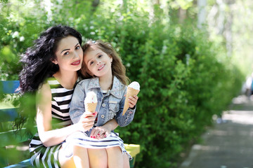 Wall Mural - Happy mom and daughter. Walk in the green park