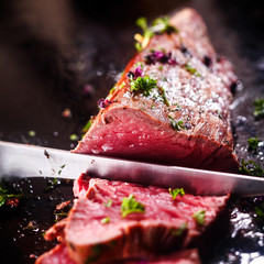 carving a portion of rare roast beef