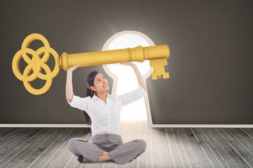 Poster - Composite image of businesswoman sitting cross legged carrying l