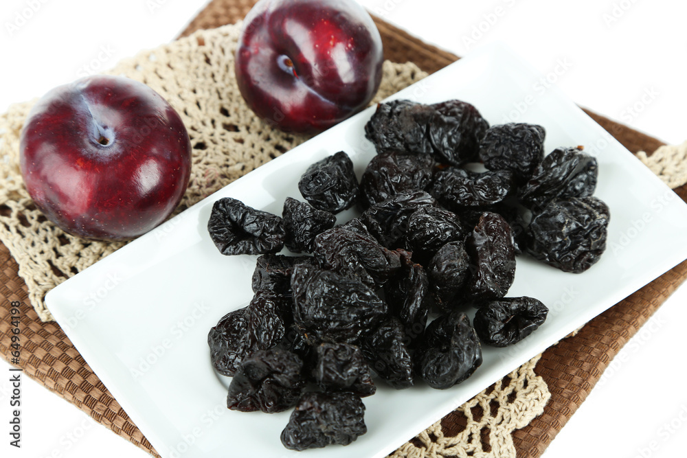 Fresh and dried plums  on napkin, isolated on white