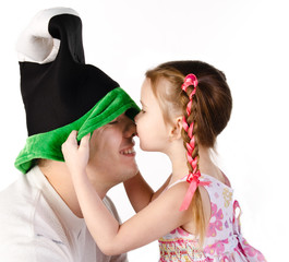 Wall Mural - Little girl kissing her father in funny cap isolated