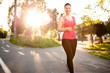 © aboutmomentsimages - Female athlete jogging around the park at sunset, running