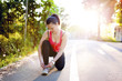 © aboutmomentsimages - portrait of a smiling female runner preparing for marathon
