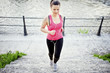 © aboutmomentsimages - Female athlete jogging and training on street