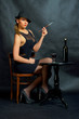 Piękna kobieta trzymająca papierosa przy stoliku.