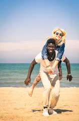 Young couple playing at the beach - Fun with piggyback jump