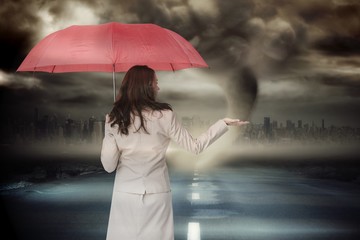 Poster - Composite image of businesswoman holding umbrella