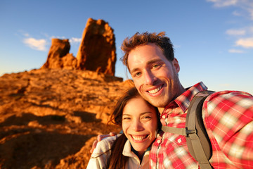 happy couple taking selfie self portrait hiking