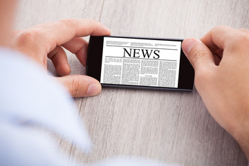 Poster - Businessman Surfing News On Smartphone At Desk