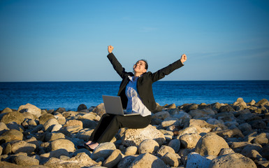 attractive free business woman working on laptop at beach