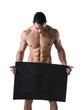 © theartofphoto - Naked young male bodybuilder holding blank board