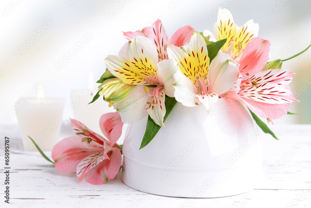 Alstroemeria flowers in vase on table on light background
