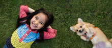 Happy Asian Girl With Her Doggy Portrait Lying On Lawn