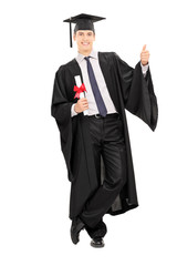 Wall Mural - Male graduate holding diploma and giving thumb up