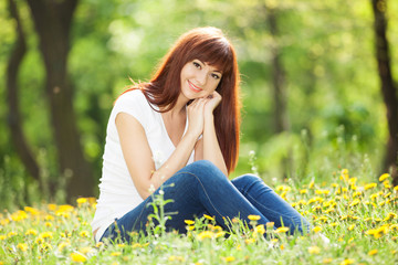 Wall Mural - Young woman in the park with flowers