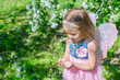 © travnikovstudio - Little girl with a ladybug in the hands at flowering apple