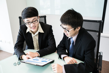 Two managers discussing contract in meeting room