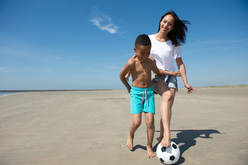 Wall Mural - Smiling mother and son playing with ball