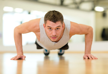 Wall Mural - concentrated man doing push-ups in the gym