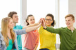 © Syda Productions - smiling students making high five gesture sitting