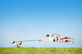 Fototapeta Konie - Hund an Leine mit fliegendem Hundebesitzer