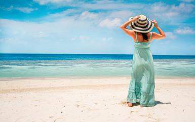 Girl walking along a tropical beach in the Maldives.