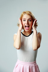 Sticker - Scared young woman shouting on gray background